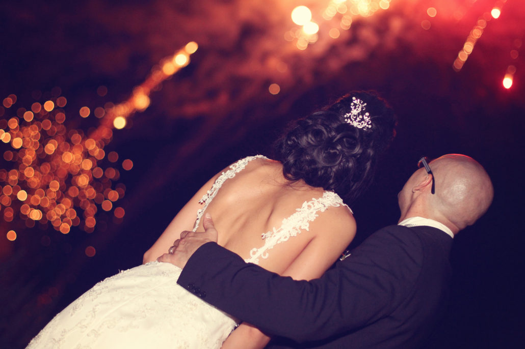 Bride and groom surrounded by fire crackers